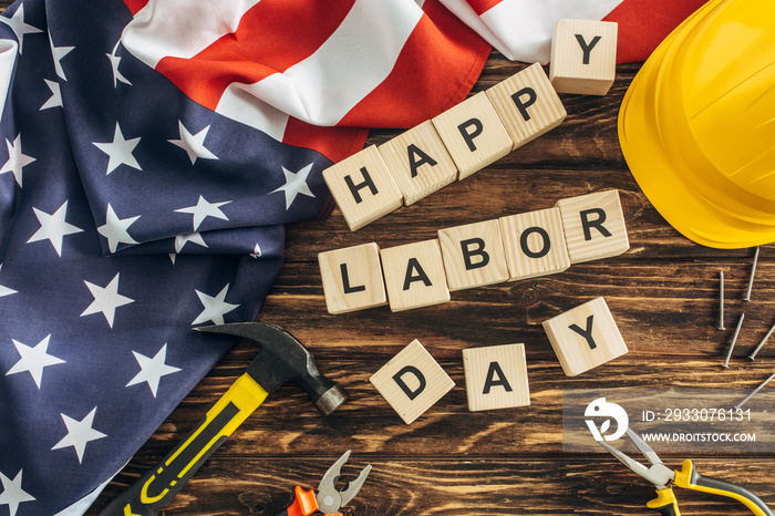 top view of american flag and instruments near safety helmet and happy labor day lettering on wooden surface