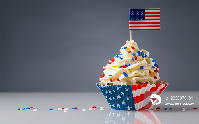 Cupcake. American Flag. US Holidays. Cake on 4th of July, Independence, Presidents Day. Tasty cupcakes with white cream icing and colored stars sprinkles. USA patriotism. Sweet dessert. Copy space.