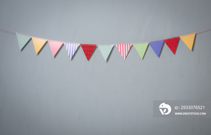 Paper party flags for decoration and covering on grey concrete textured copy space background