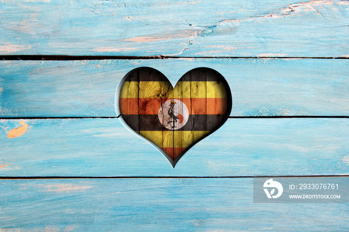 Love Uganda. Heart and flag on a blue wooden board