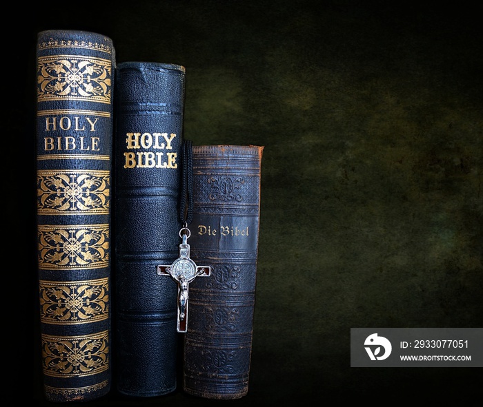 Spines of some very old King James  Bibles  with no copyright - one in German Language and crucifix hanging down