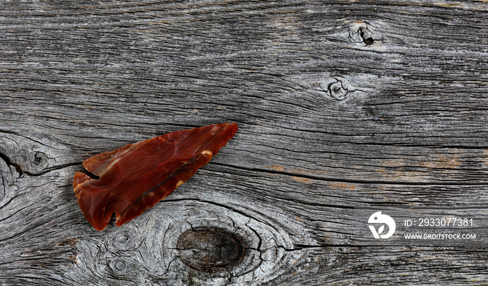 One Native American arrowhead on rustic wood