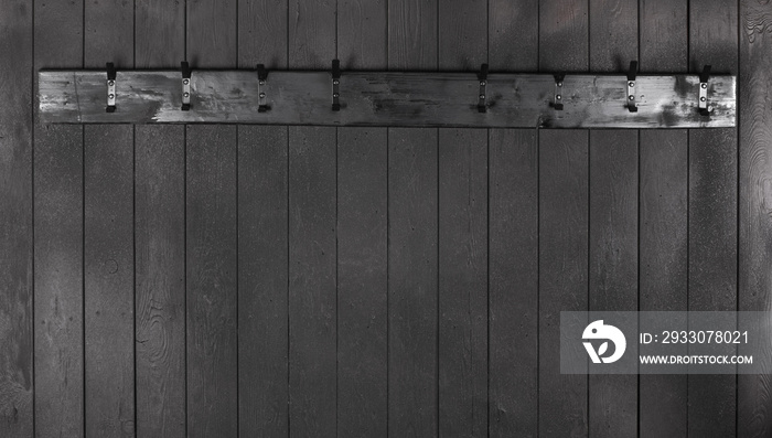 old black wooden hanger on a black wooden wall