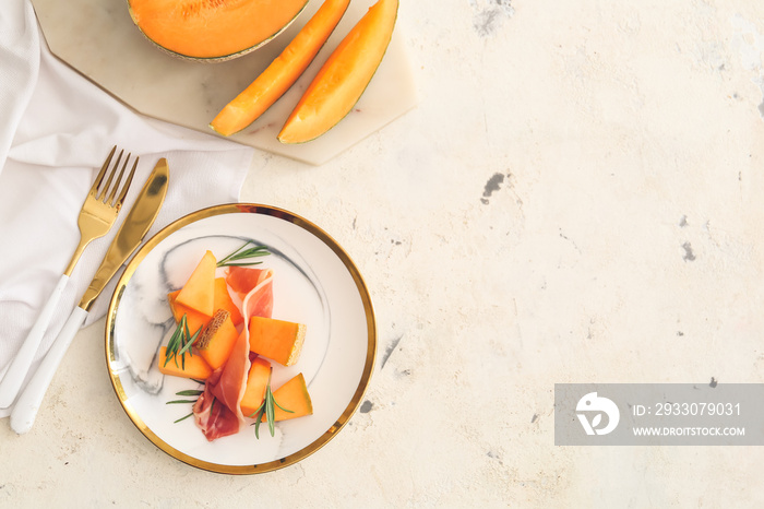 Plate with delicious melon and prosciutto on light background