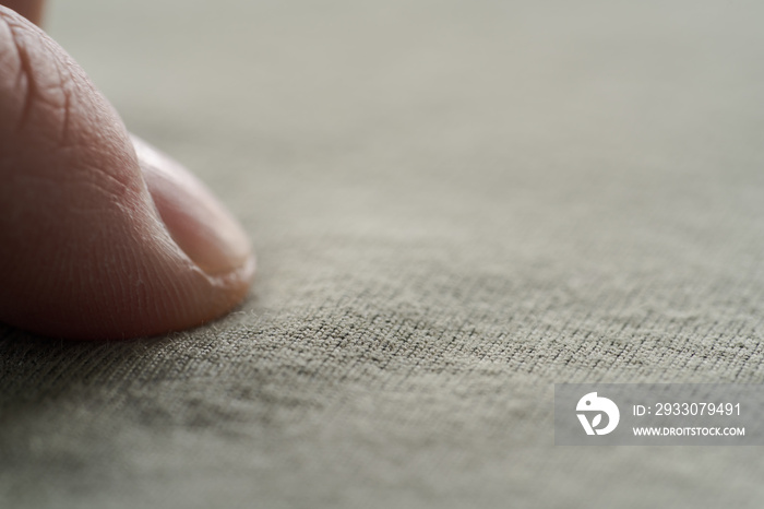 man hand touching green cotton fabric