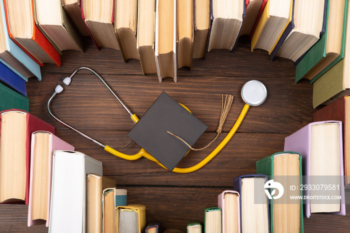 Medical degree education concept - stack of books in heart shape and stethoscope on the library table. Love to study medicine