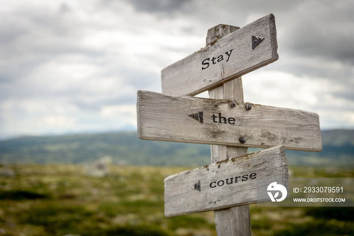 stay the course quote text on wooden signpost outdoors in nature.