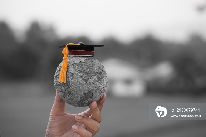 Education world knowledge ideas. Graduation cap on students holding gray paper mache craft earth globe in hands. Concept of global business study abroad inter educational.Back to School