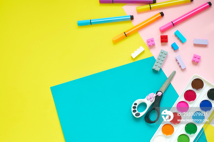 School supplies, stationery on yellow background - space for caption. Child ready to draw with pencils and make application of colored paper. Top view.