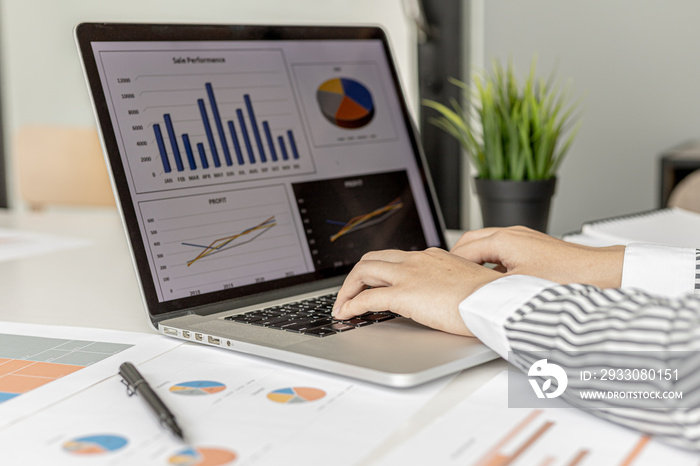 A businesswoman typing on a laptop keyboard, she is preparing a financial summary to bring to a meeting with business partners. Concept of company financial management. Checking financial information.