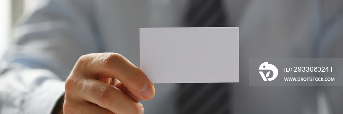 Male arm in suit give blank calling card to visitor