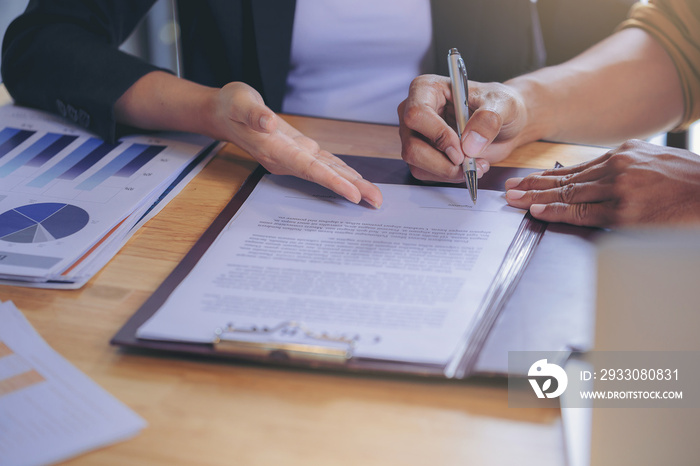 Businessman puts signature on contract at business meeting and passing money after negotiations with business partners. Selected focus