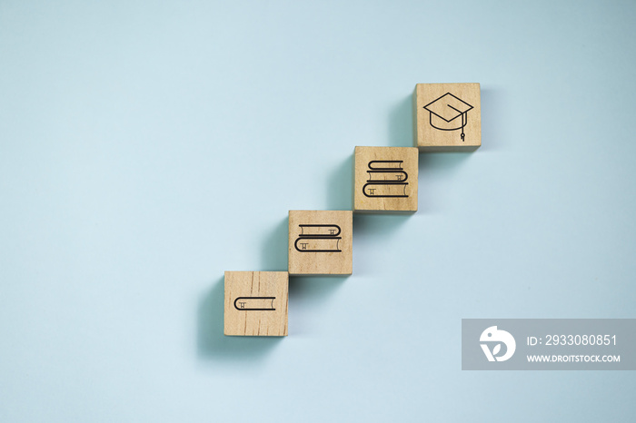 Top view wooden blocks set to step with book icon to graduate icon. Concept for learning and education.