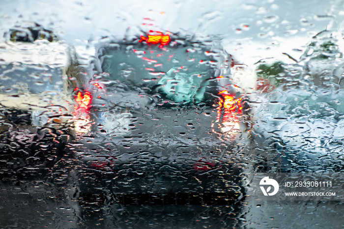 The car in a reverse gear braking and paying attention when parking to prevent an accident in a bad rainy weather