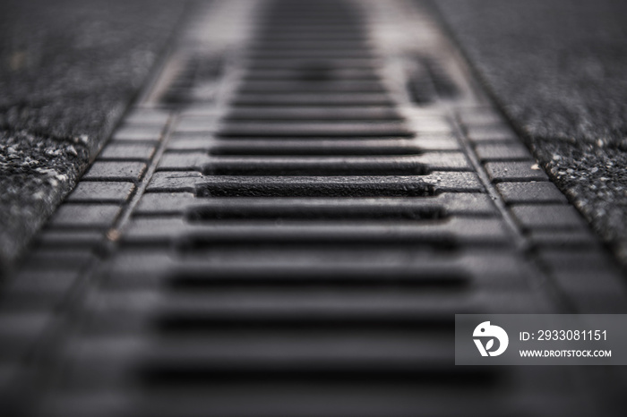 Street and Driveway Storm Water Drain Close Up with Shallow Depth of Field. Infrastructure Element Designed to Drain Excess Rain.