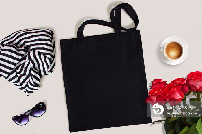 Black blank cotton eco tote bag with red roses, glasses, scarf and a cup of coffee, styled design mockup