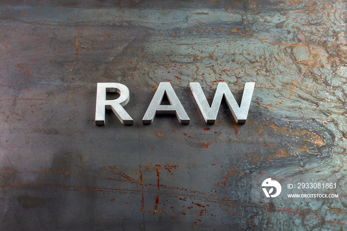 the word raw laid with silver metal letters on hot rolled steel sheet surface