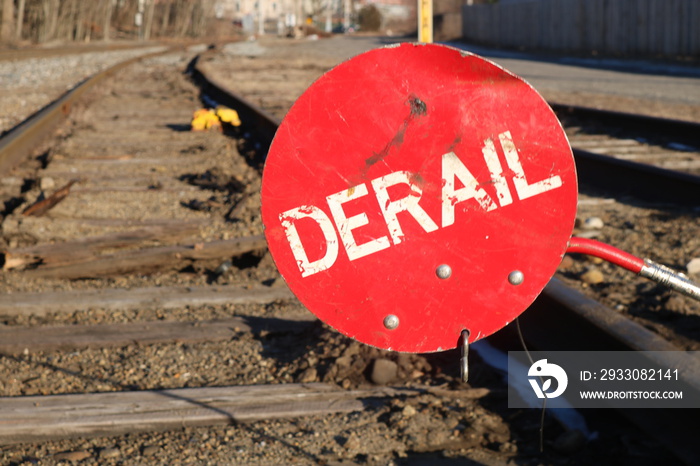 Red derail warning symbol sign on old abandoned railroad tracks