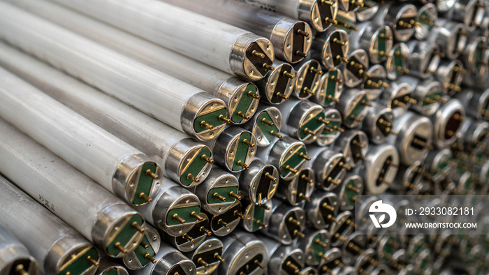 Old fluorescent lamps are stacked in rows. Background view