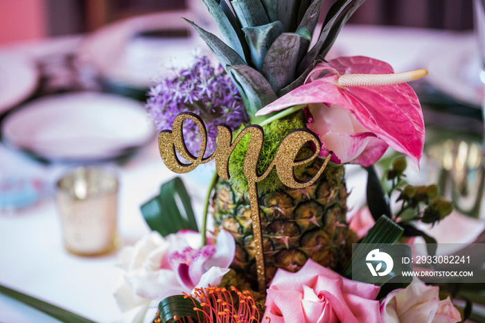 event table Hawaiian theme centerpiece with number one and pineapple