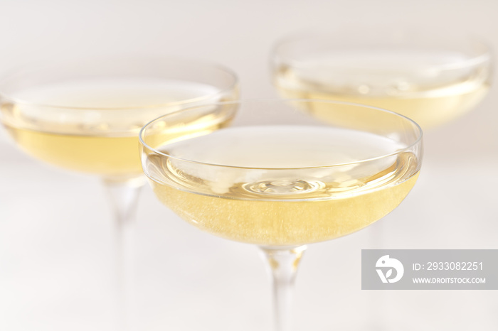 Three champagne coupe on a white background, selective focus.