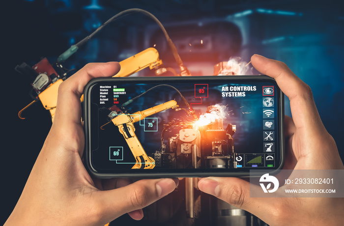 Engineer controls robotic arms by augmented reality industry technology application software. Smart robot machine in future factory working in concept of Industry 4.0 or 4th industrial revolution.