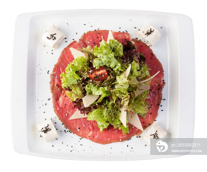 Mix salads on meat carpaccio with Philadelphia cheese. On a white background