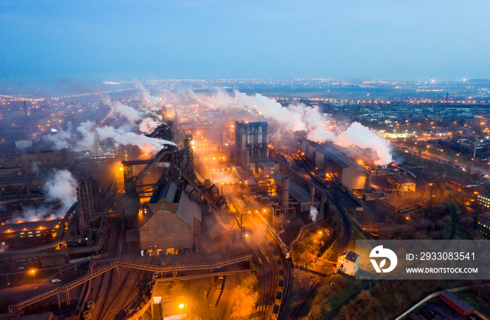 Aerial view. Emission to atmosphere from industrial pipes. Smokestack pipes shooted with drone. Night scene