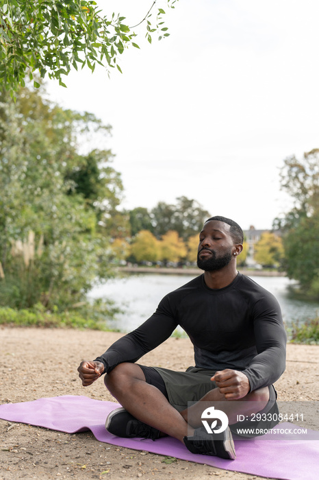 Athletic man meditating in park