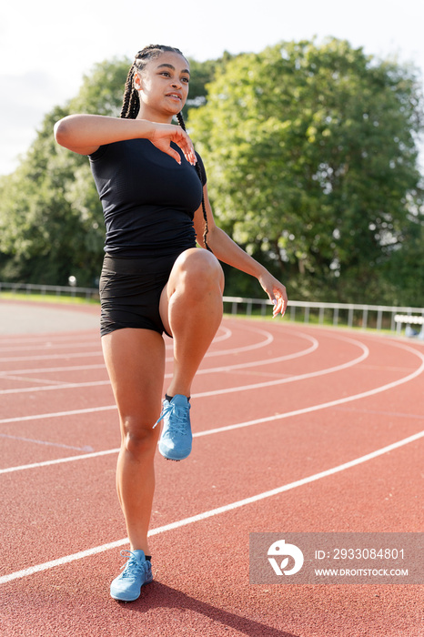 Female athlete exercising at sports track