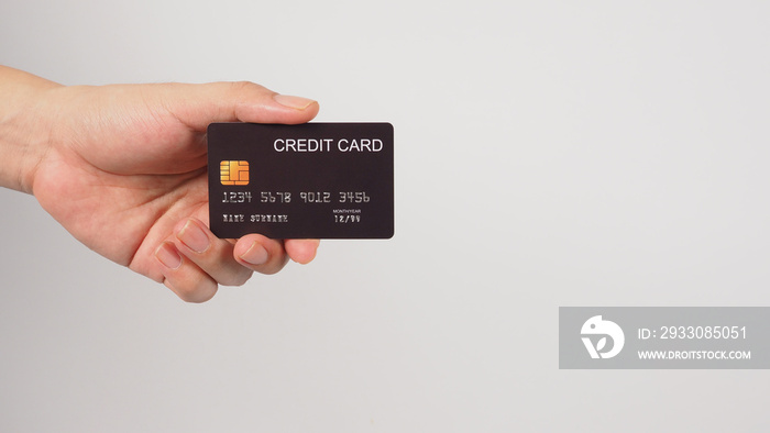 Hand is holding black credit card isolated on white background