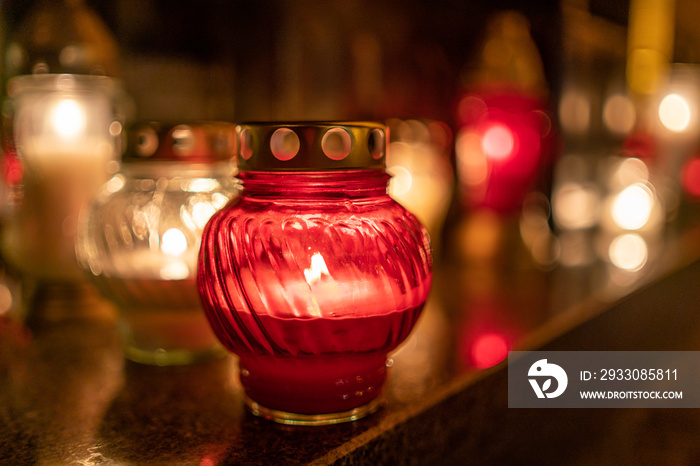 Jars with burning candles on stone surface at night