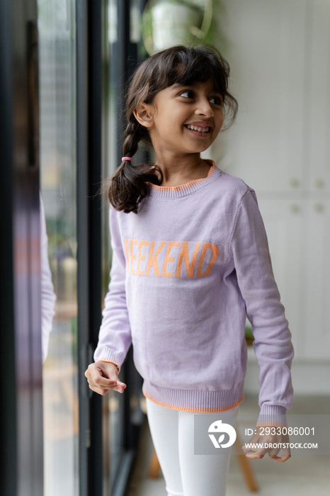 Little girl standing near window