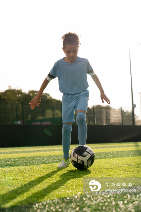 Girl (6-7) playing soccer on soccer field