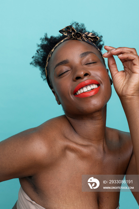 Smiling woman with closed eyes, wearing red lipstick