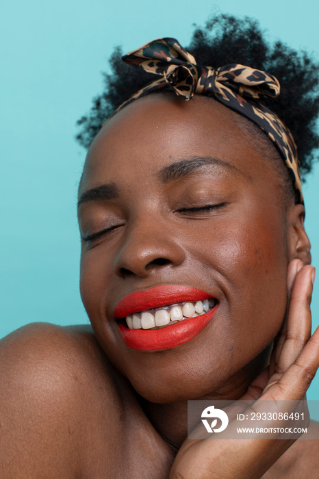 Portrait of smiling woman with closed eyes, wearing red lipstick