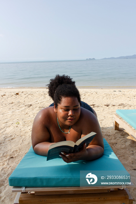 Young woman relaxing and reading on beach