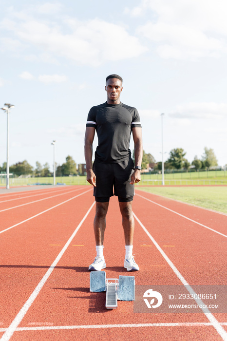 Athlete standing in front of starting line at stadium