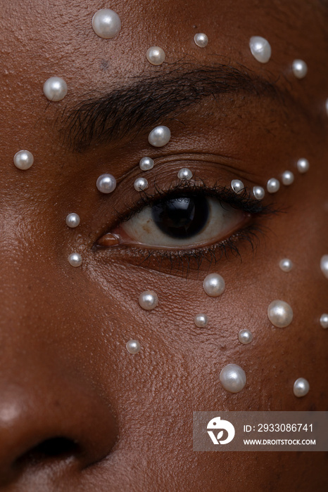 Close-up of woman with brown eyes, wearing pearl freckles