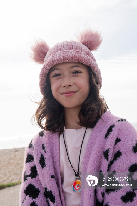 Portrait of smiling girl on beach on cloudy day