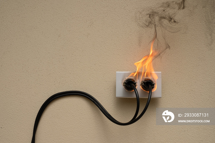 On fire electric wire plug Receptacle on the concrete wall exposed concrete background