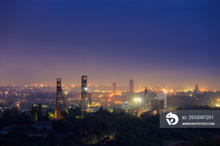 Industrial area with a large number of mines for underground mining of ore or coal. Night view of the towers of the mine shafts.