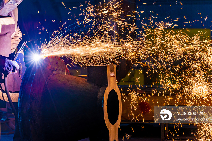 Welding with a graphite electrode, a lot of sparks fly in different directions. Fireworks from the fire from the gas burns of metal.