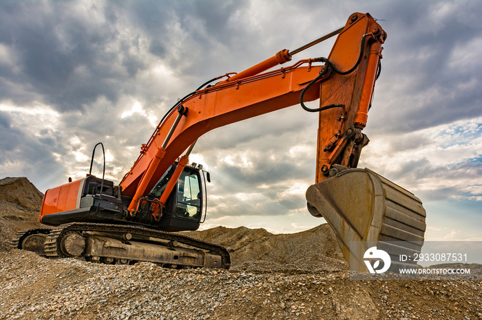 Large excavator on a gravel mountain, making material movements