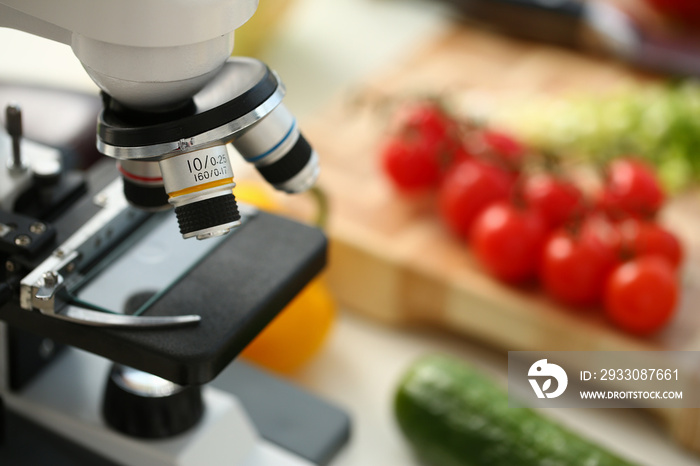 Microscope head on kitchen background vegetables concept nitrates