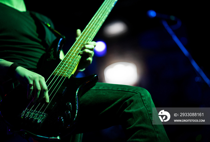 A closeup of a guitar during a rock concert