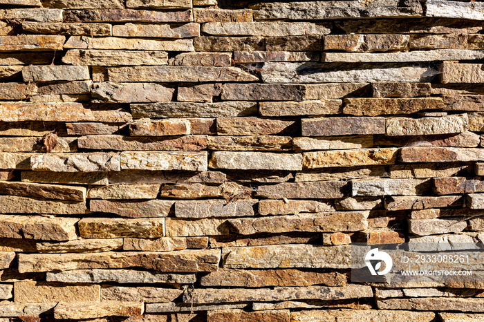 Background of stone wall texture. The surface of the stones is brown