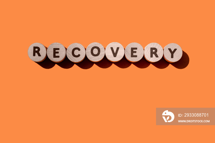 Recovery word from wooden letters on an orange background. Restoring business sectors and economies affected by the global financial crisis due to the coronavirus pandemic. Banner. Copy space