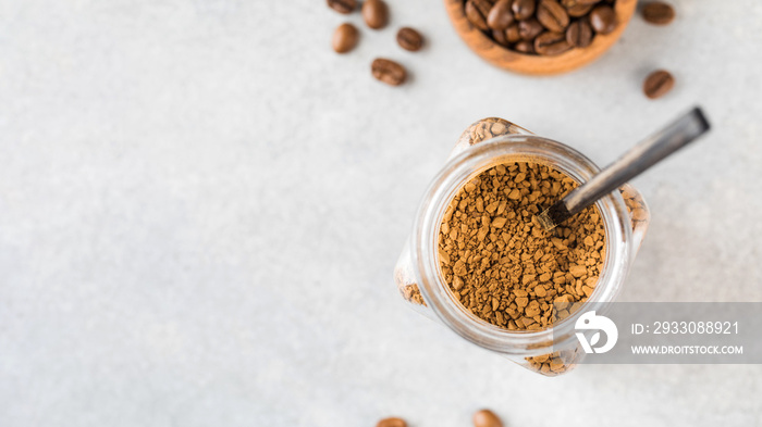 A jar with instant coffee and a spoon inside top view. Copy space.