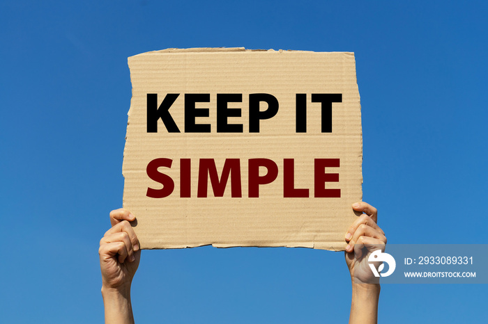 Keep it simple poster held by 2 hands with isolated blue sky background